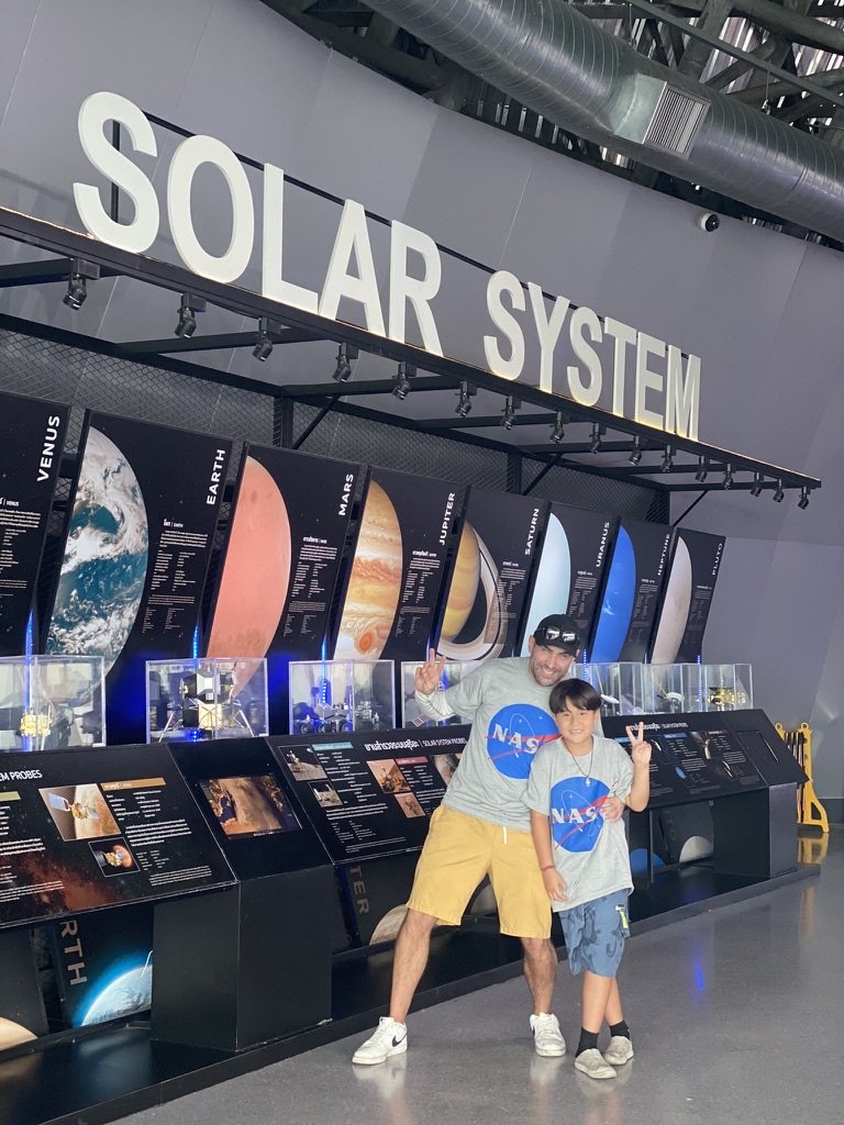 Ben and his son in matching NASA T-shirts at a museum exhibit