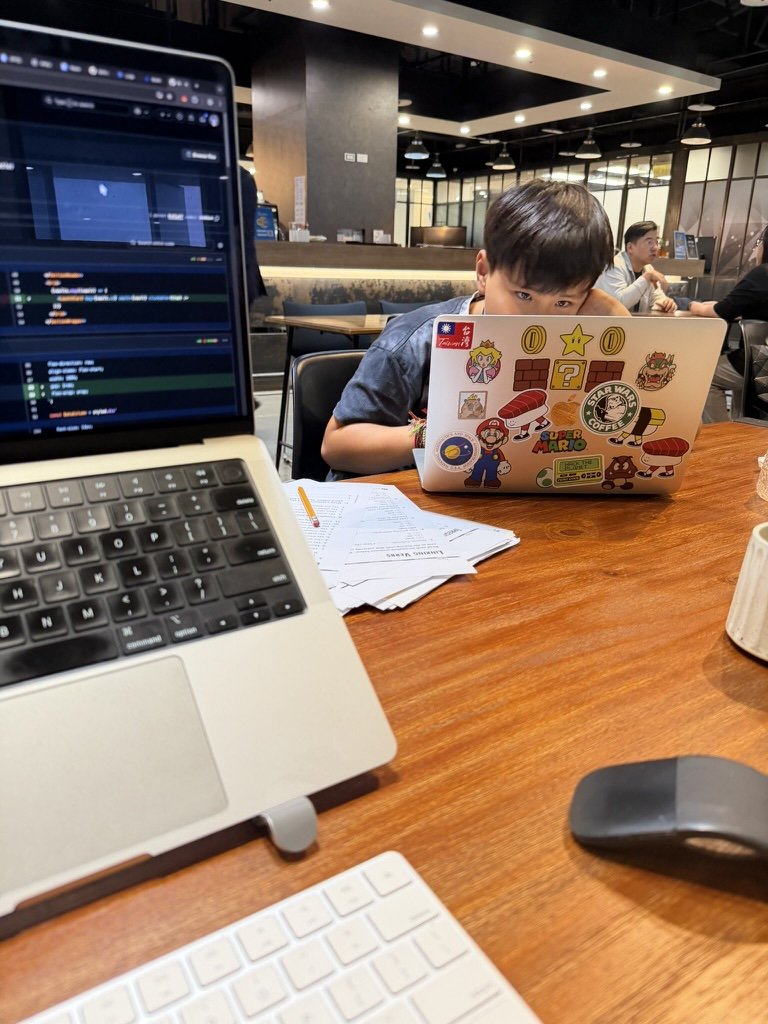 Student coding creative web projects on a sticker-covered laptop