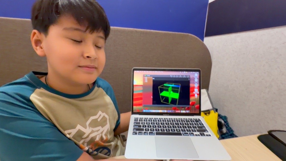 Student proudly showcasing his 3D graphics coding project on his laptop